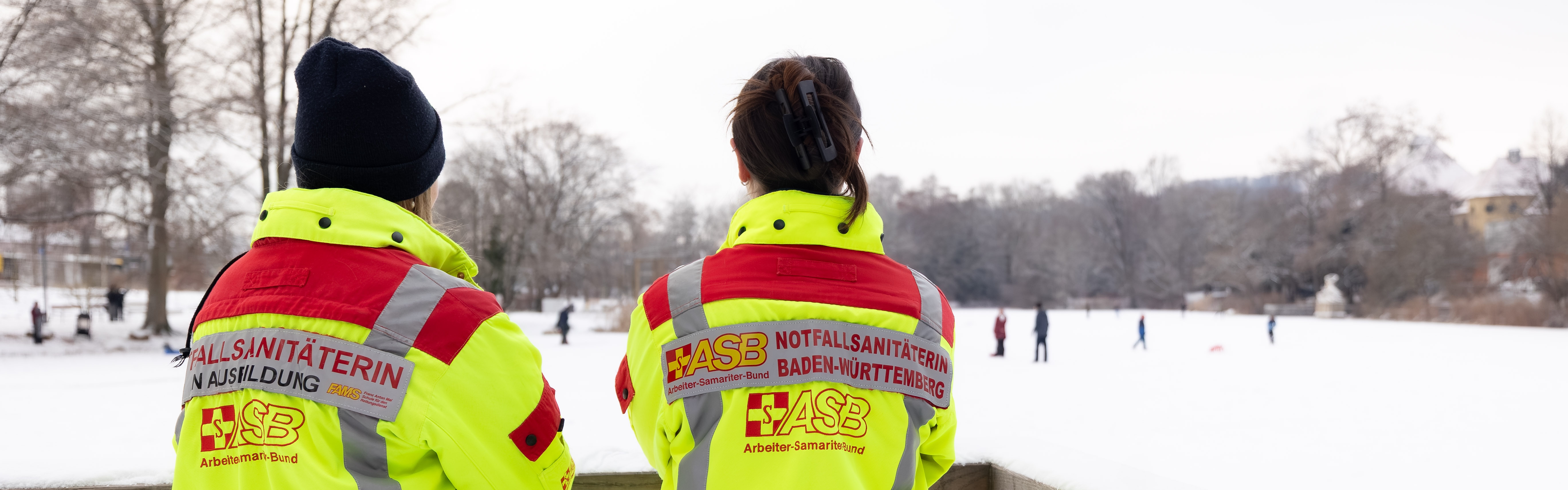 Zwei Notfallsanitäterinnen des ASB Neckar-Alb blicken auf einen zugefrorenen See, Anlagensee in Tübingen, Symbolbild um auf Gefahren beim Betreten von Eisflächen hinzuweisen 