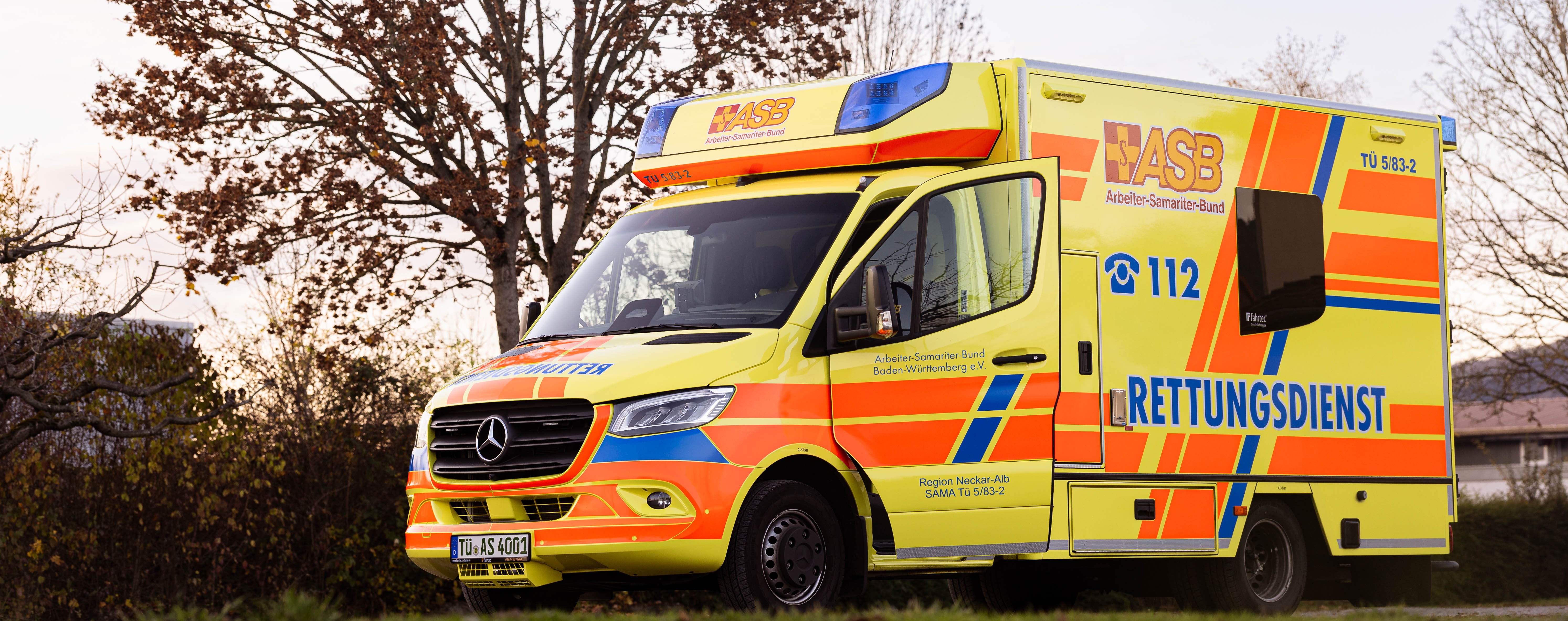 Rettungswagen des ASB Neckar-Alb im Sonnenuntergang auf einem freien Parkplatz