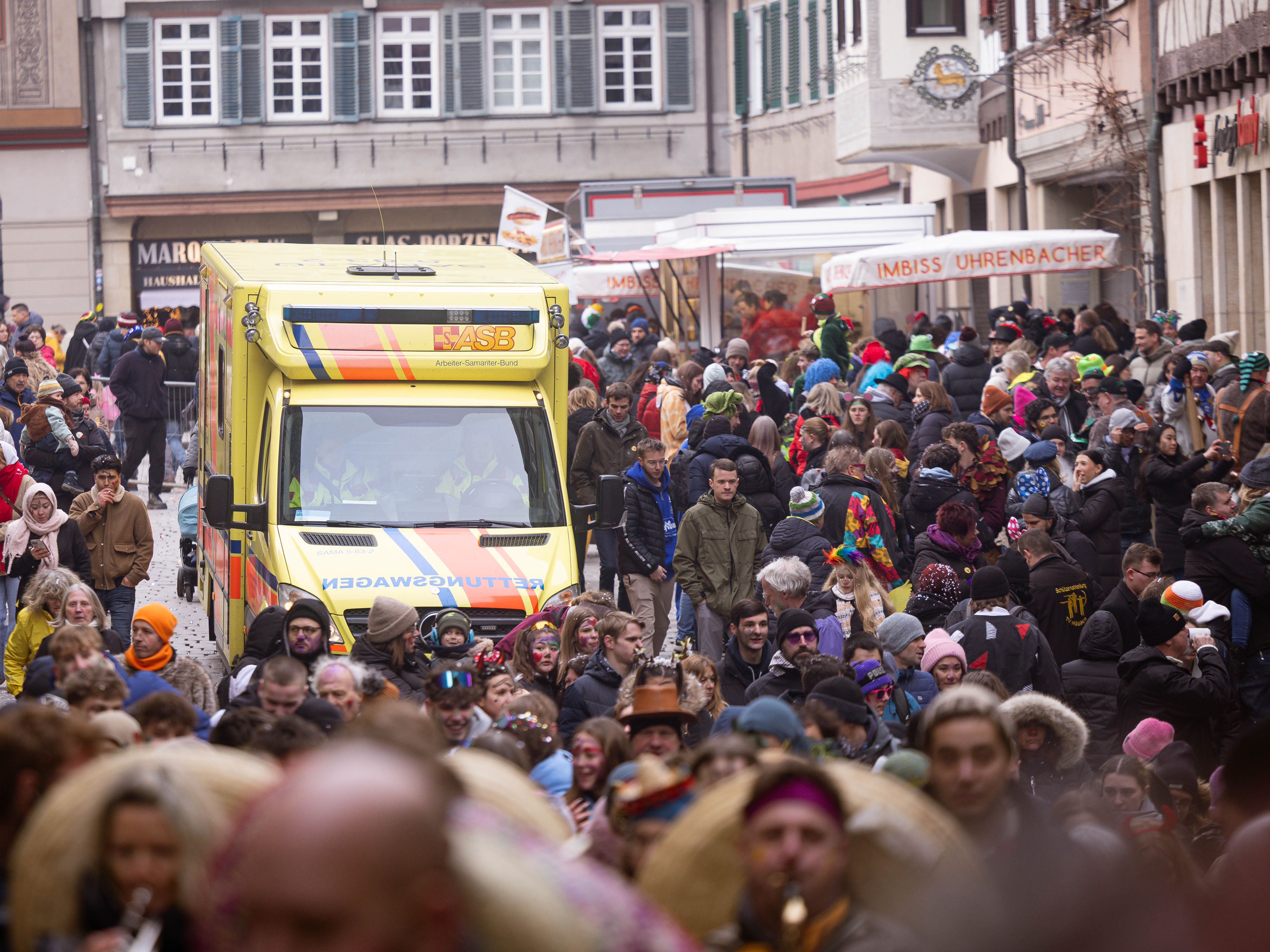 Rettungswagen des ASB Neckar-Alb beim Tübinger Fasnetsumzug, auf dem Marktplatz inzwischen von sehr vielen Besuchern